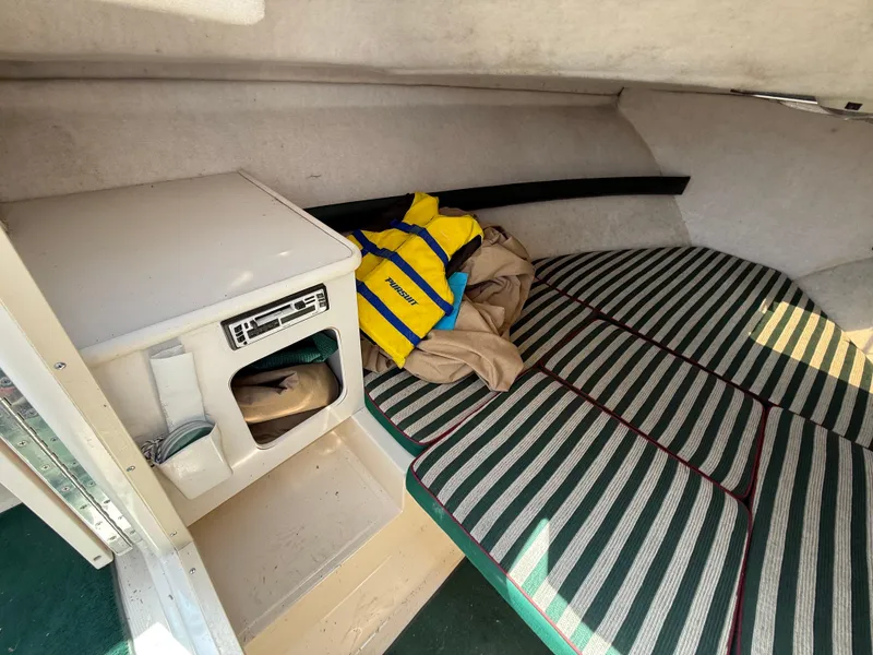 Slide: The Image of Interior of 1996 Pursuit 2460 Denali boat with striped seating and life jacket. - 19
