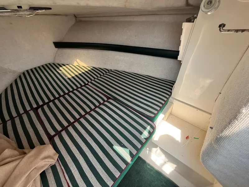 Slide: The Image of Interior cabin of a 1996 Pursuit 2460 Denali boat with striped cushions. - 20