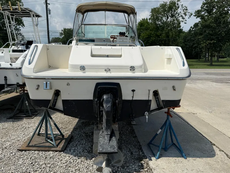 Slide: The Image of 1996 Pursuit 2460 Denali boat on stands, rear view, outdoors. - 4