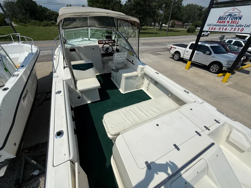 Slide: The Image of 1996 Pursuit 2460 Denali boat interior with seating and steering wheel, parked outdoors. - 8