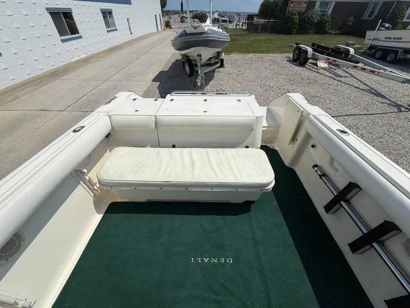Slide: The Image of 1996 Pursuit 2460 Denali boat interior with white seating and green carpet. - 9