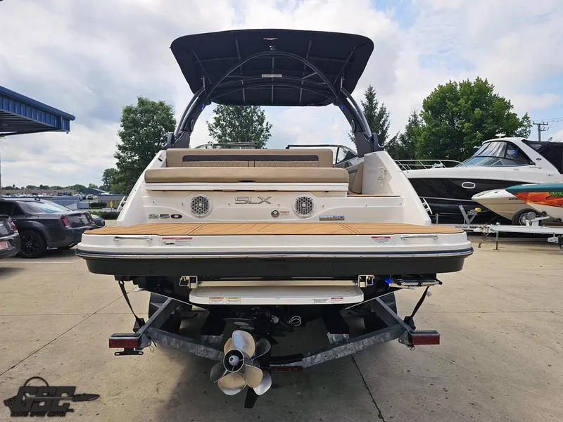 Slide: The Image of 2016 Sea Ray 250 SLX boat, rear view, parked on a trailer at a marina. - 25