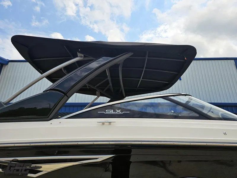 Slide: The Image of 2016 Sea Ray 250 SLX boat with sleek design and canopy against a blue sky. - 5