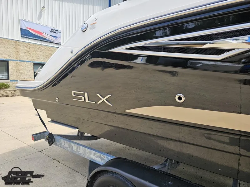 Slide: The Image of 2016 Sea Ray 250 SLX boat on trailer, sleek black exterior, parked outside a building. - 7