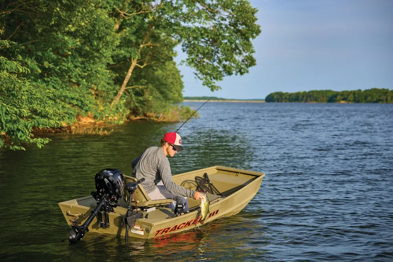 Slide: The Image of Manufacturer Provided Image: Man fishing on a 2026 Tracker Grizzly 10 Jon boat in a serene lake. - 20