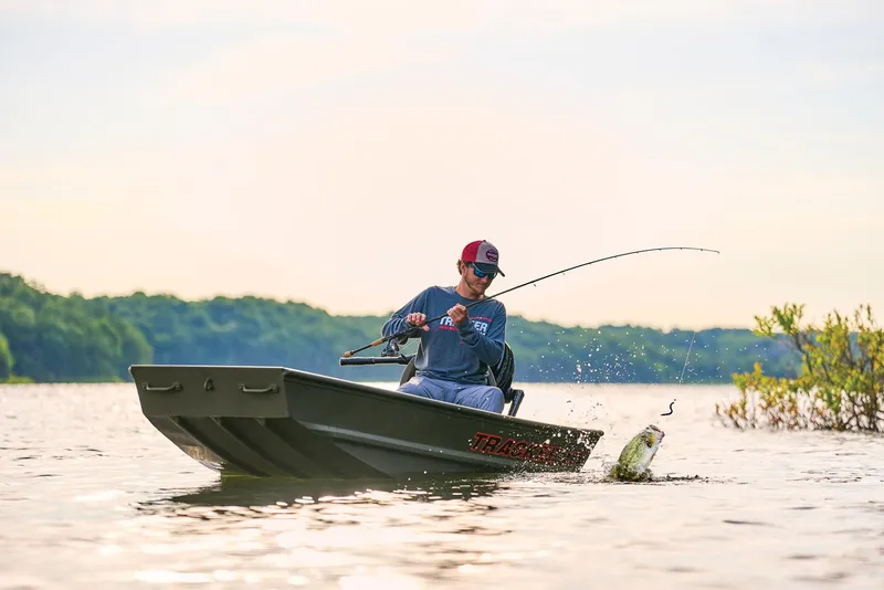 Slide: The Image of Manufacturer Provided Image: Man fishing from 2026 Tracker Grizzly 10 Jon boat on a serene lake. - 22