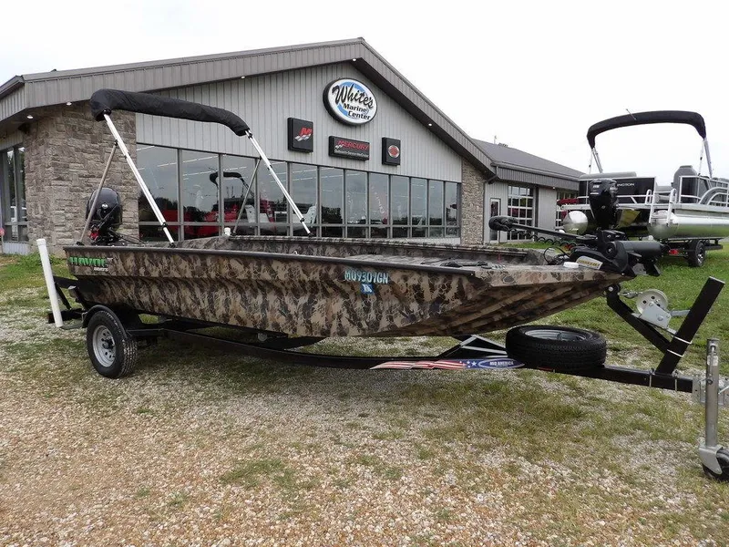 Slide: The Image of 2021 Havoc VJST-C 1756 boat with camouflage design on a trailer outside a dealership. - 1