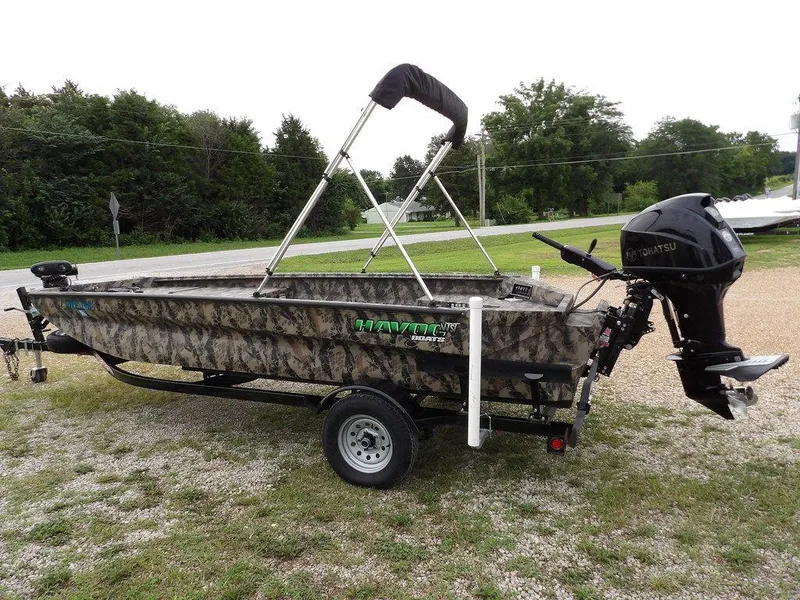 Slide: The Image of 2021 Havoc VJST-C 1756 boat with camouflage design on a trailer, featuring a Tohatsu outboard motor. - 12