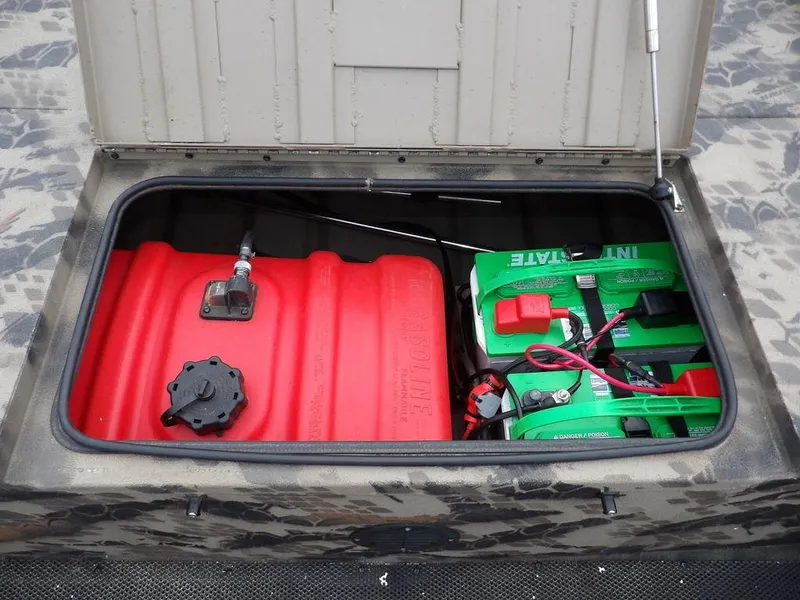Slide: The Image of Open storage compartment with red fuel tank and green batteries in a 2021 Havoc VJST-C 1756. - 18