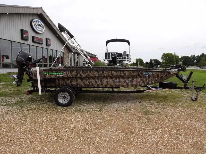 Slide: The Image of 2021 Havoc VJST-C 1756 boat with camouflage design on a trailer outside a marine center. - 2