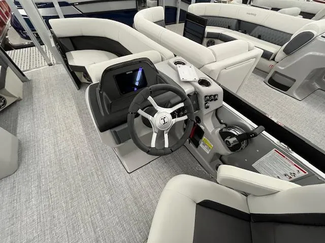 Slide: The Image of 2025 Harris Cruiser 210 boat interior with modern steering console and plush seating. - 19
