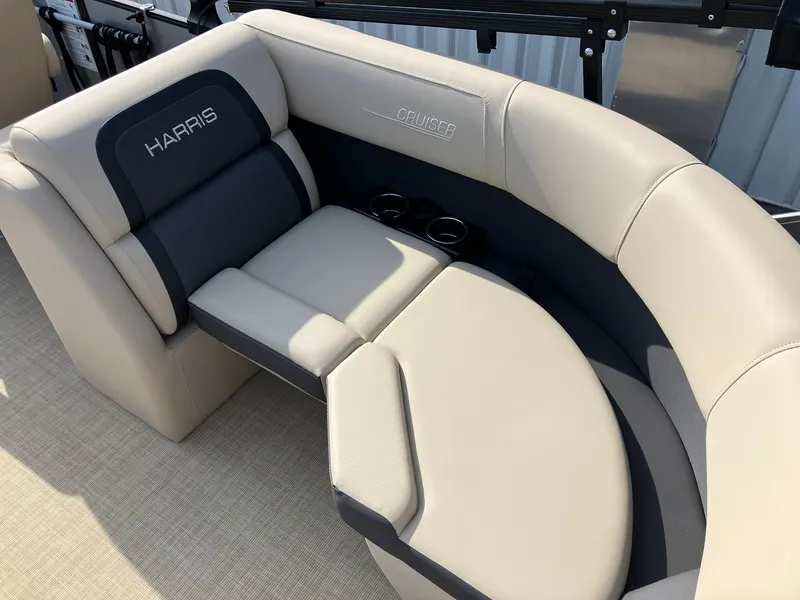 Slide: The Image of 2025 Harris Cruiser 230 boat interior with beige and gray seating, featuring cup holders. - 11