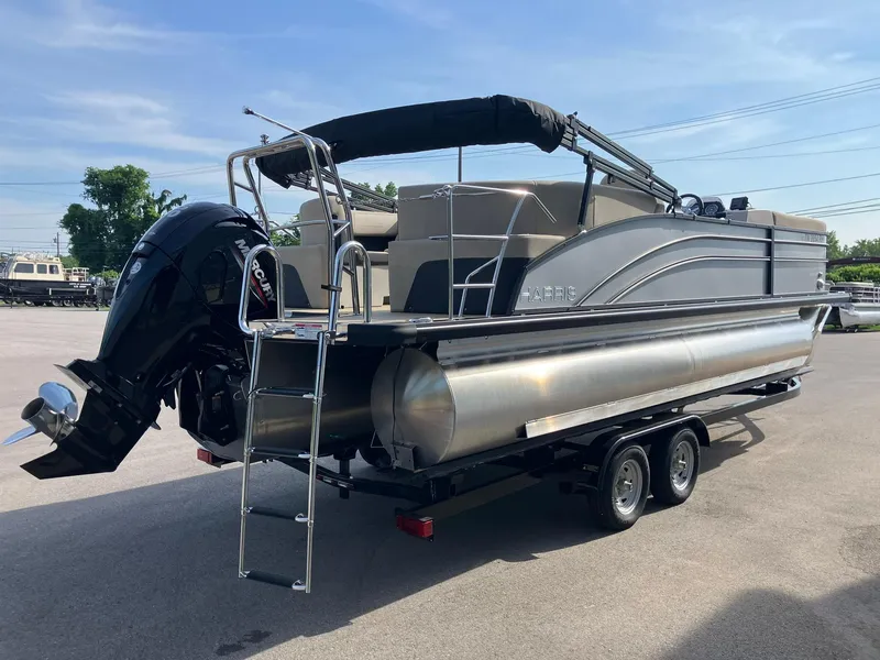 Slide: The Image of 2025 Harris Cruiser 230 pontoon boat on trailer, featuring a Mercury outboard motor. - 2