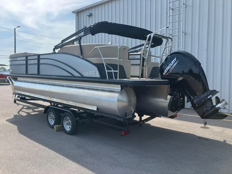 Slide: The Image of 2025 Harris Cruiser 230 pontoon boat with Mercury outboard motor on trailer. - 3