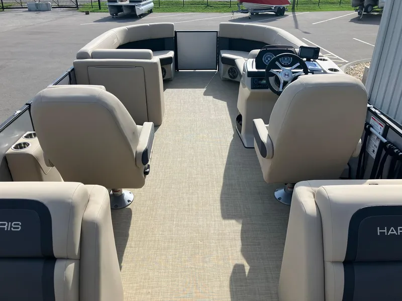 Slide: The Image of 2025 Harris Cruiser 230 pontoon boat interior with beige seating and modern dashboard. - 9