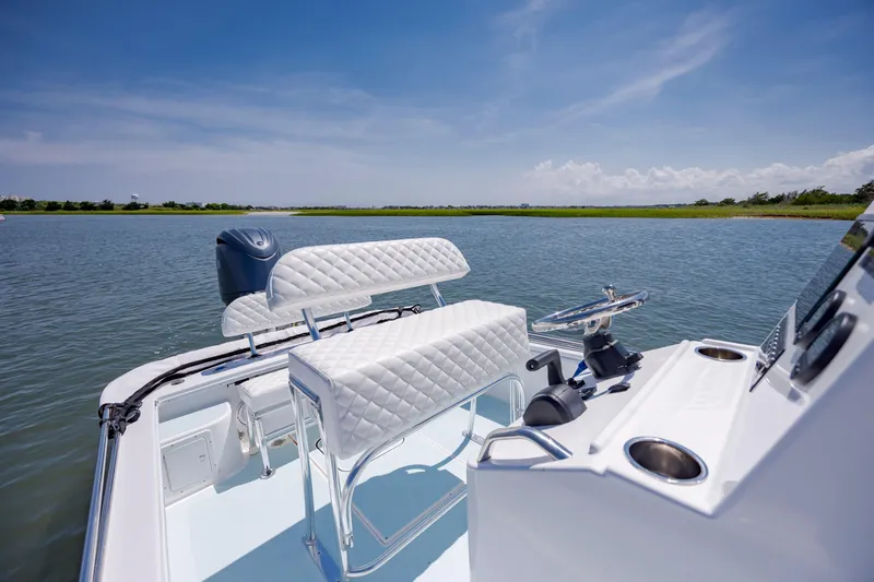 Slide: The Image of Modern Spanish Wells 21 boat interior, 2025 model, featuring sleek white seating and steering wheel on calm water. - 10