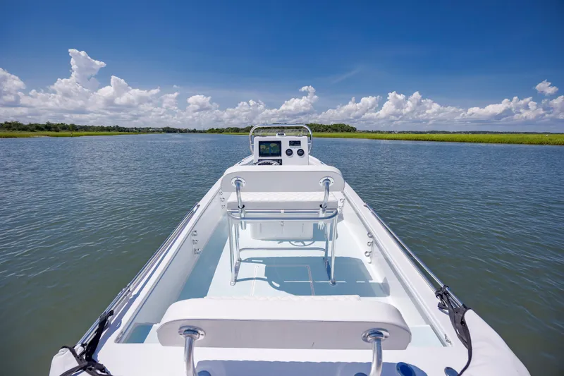 Slide: The Image of 2025 Spanish Wells 21 boat cruising on a serene lake under a clear blue sky. - 11