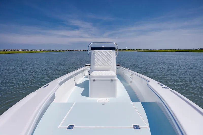 Slide: The Image of 2025 Spanish Wells 21 boat on calm water under clear blue sky. - 17