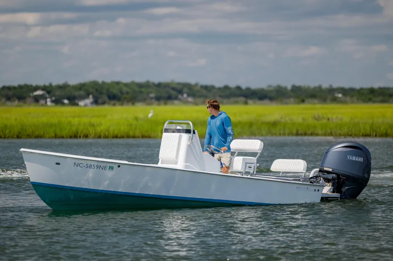 Slide: The Image of 2025 Spanish Wells 21 boat with Yamaha engine on calm water, person steering. - 3