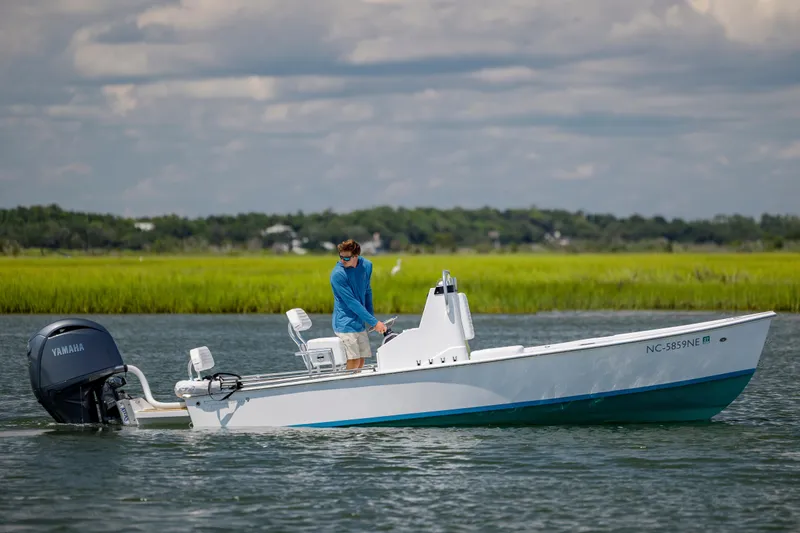 Slide: The Image of A person on a 2025 Spanish Wells 21 boat with Yamaha motor in a scenic waterway. - 4