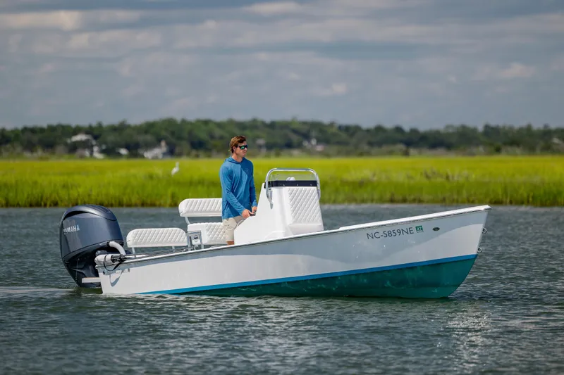 Slide: The Image of Man on a 2025 Spanish Wells 21 boat with Yamaha engine, cruising in a scenic waterway. - 5