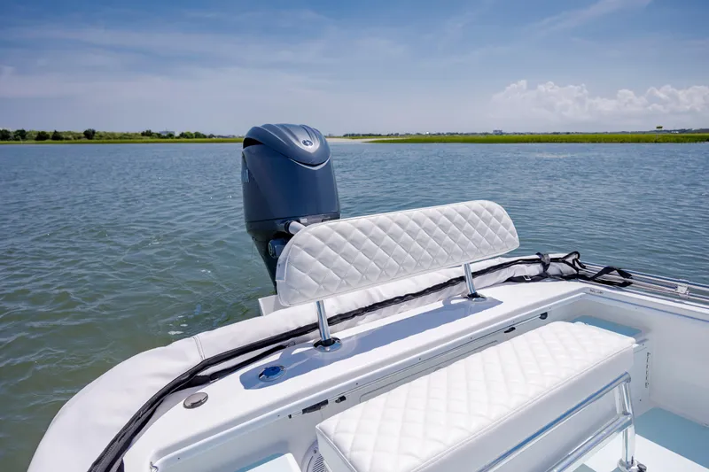 Slide: The Image of 2025 Spanish Wells 21 boat with white seating, cruising on a calm lake under a clear sky. - 8