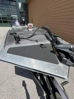 Slide: The Image of 2015 Tracker Pro 170 boat, front deck view with fishing equipment, parked outdoors. - 3