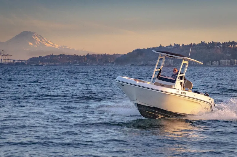 Slide: The Image of 2021 Bayliner Trophy boat cruising on scenic water with mountain backdrop. - 4