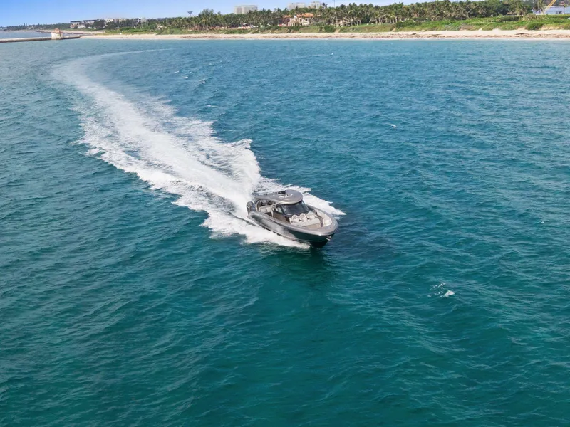 Slide: The Image of 2024 Mystic Powerboats M5200 cruising on open ocean near coastline. - 10