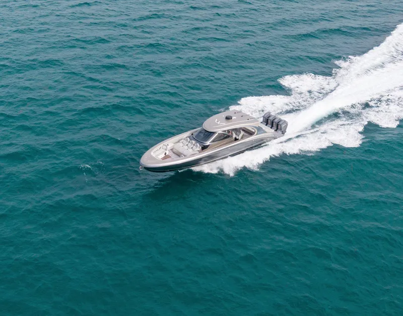 Slide: The Image of 2024 Mystic Powerboats M5200 cruising on open water, showcasing sleek design and powerful engines. - 16