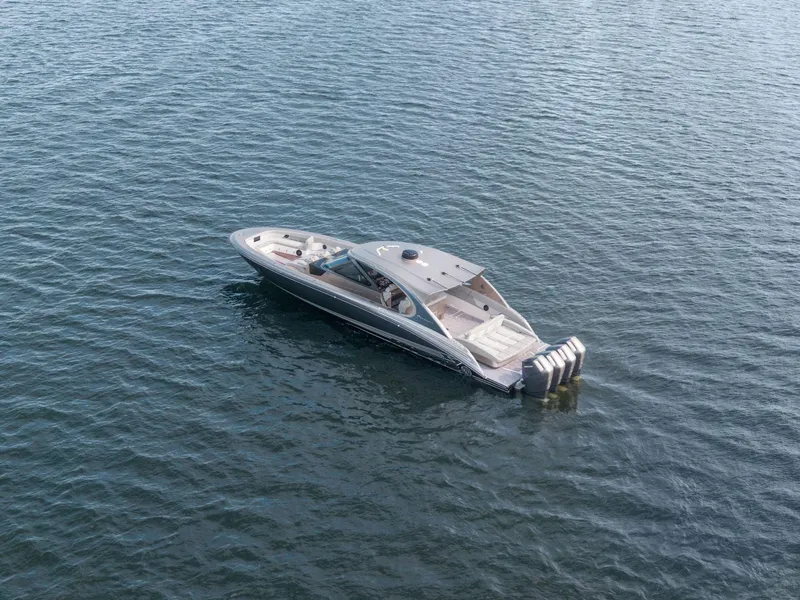 Slide: The Image of 2024 Mystic Powerboats M5200 luxury boat on calm water, aerial view. - 22