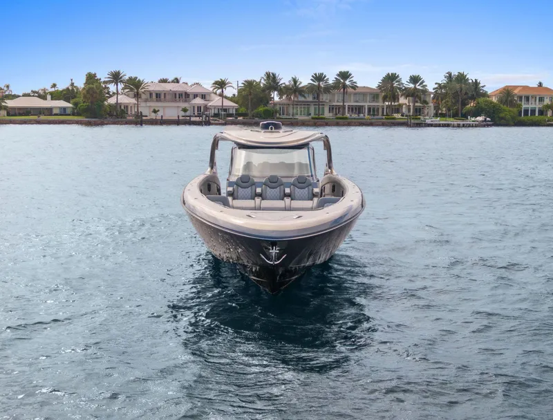 Slide: The Image of 2024 Mystic Powerboats M5200 on water, luxury waterfront homes in background. - 24