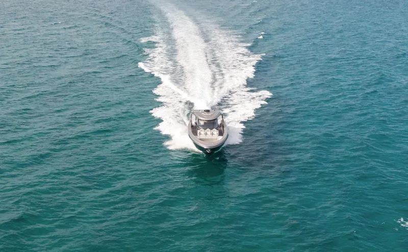 Slide: The Image of 2024 Mystic Powerboats M5200 cruising on open water, aerial view. - 31
