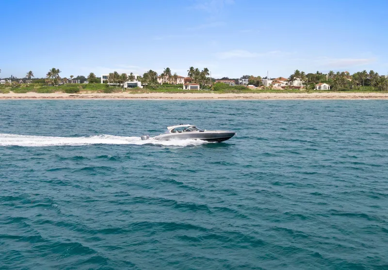 Slide: The Image of 2024 Mystic Powerboats M5200 cruising on ocean near scenic coastline. - 32