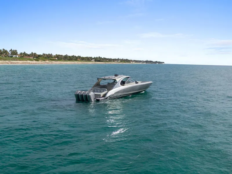 Slide: The Image of 2024 Mystic Powerboats M5200 cruising on open water near a scenic coastline. - 33