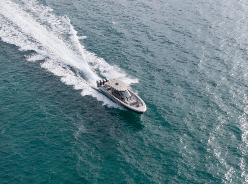 Slide: The Image of 2024 Mystic Powerboats M5200 cruising on open water, leaving a trail of white wake. - 39
