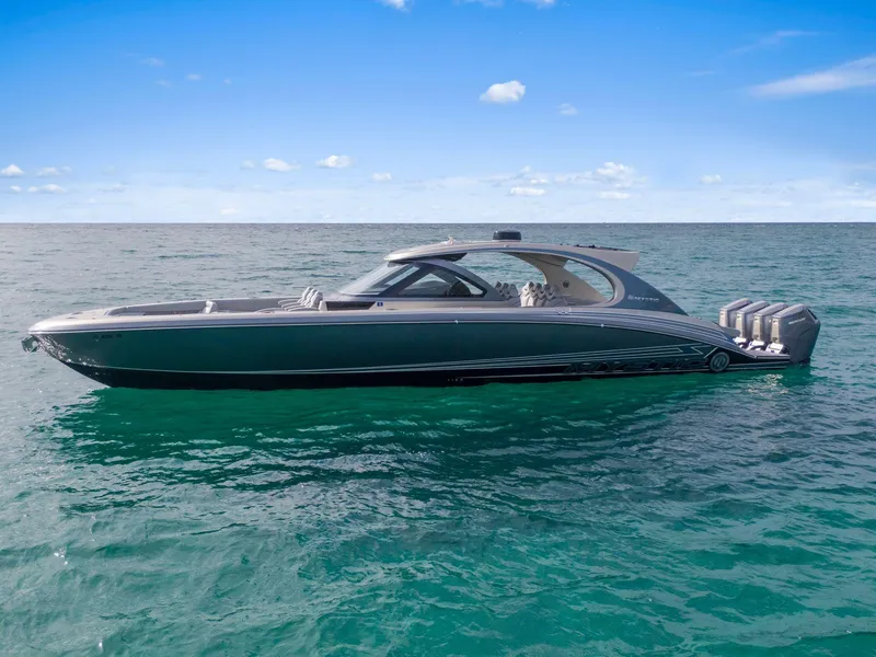 Slide: The Image of 2024 Mystic Powerboats M5200 luxury boat on open water under clear blue sky. - 45