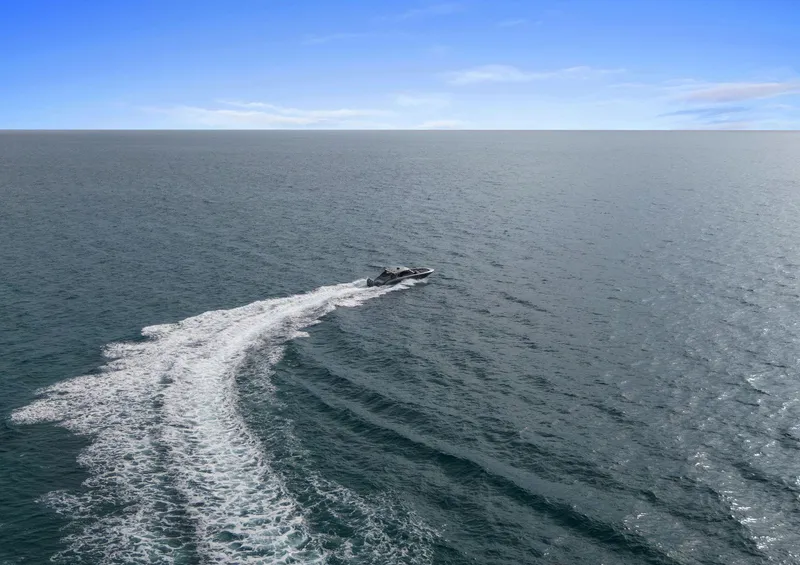Slide: The Image of 2024 Mystic Powerboats M5200 cruising on open ocean under clear blue sky. - 47