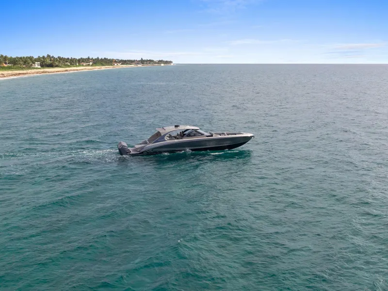 Slide: The Image of 2024 Mystic Powerboats M5200 cruising on open ocean near coastline. - 49