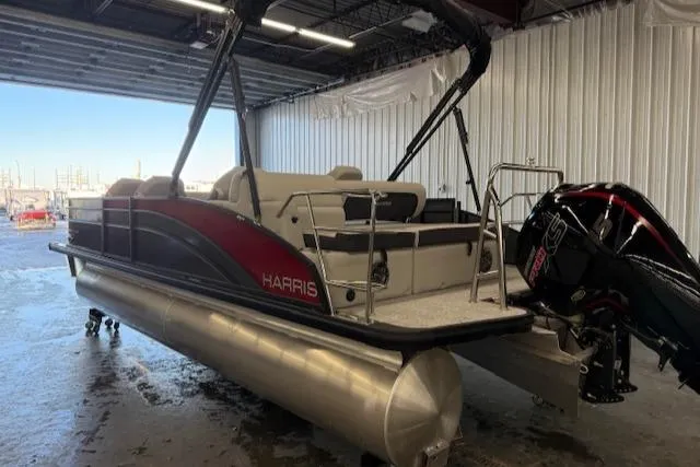 Slide: The Image of 2025 Harris Cruiser 230 pontoon boat in a warehouse, featuring sleek design and powerful engine. - 18