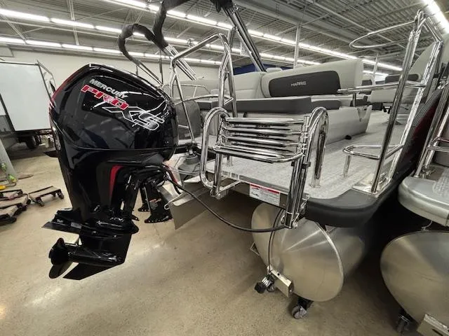 Slide: The Image of 2025 Harris Cruiser 230 pontoon boat with Mercury Pro XS outboard motor in showroom. - 5