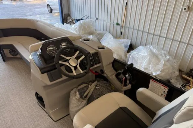 Slide: The Image of 2025 Harris Cruiser 230 boat interior with steering wheel and seating in a storage area. - 9