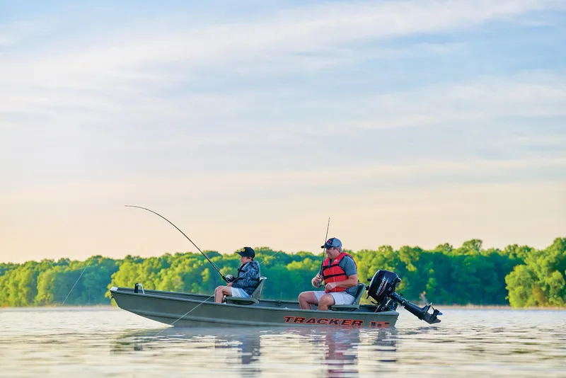 Slide: The Image of Manufacturer Provided Image: Two people fishing on a 2026 Tracker Grizzly 12 Jon boat in a serene lake. - 15
