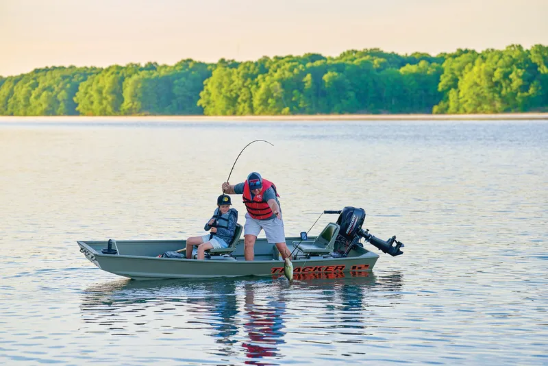 Slide: The Image of Manufacturer Provided Image: 2026 Tracker Grizzly 12 Jon boat on a serene lake, two people fishing. - 17