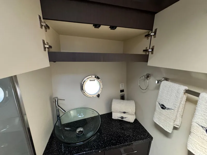 Slide: The Image of Luxurious bathroom in 2014 Marquis 420 Sport Bridge yacht with glass sink and porthole. - 16