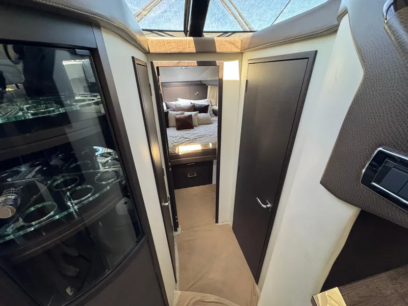 Slide: The Image of Interior of 2014 Marquis 420 Sport Bridge yacht, featuring a cozy bedroom and elegant cabinetry. - 18