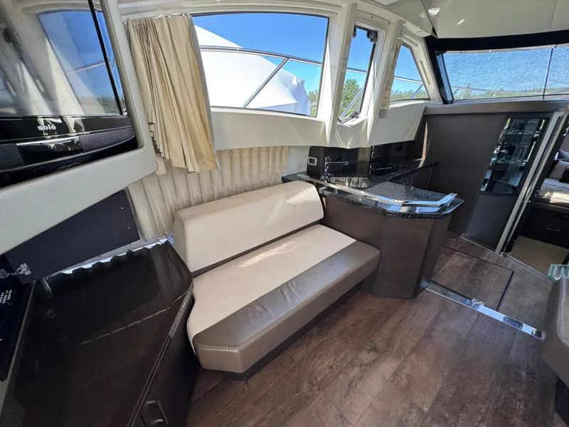 Slide: The Image of Interior of 2014 Marquis 420 Sport Bridge yacht with seating and kitchenette. - 22