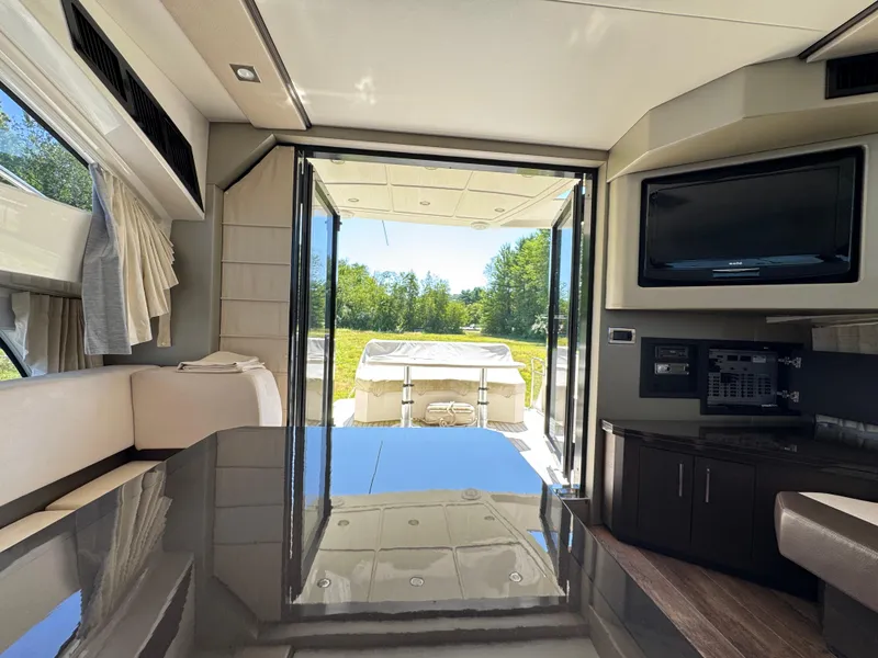 Slide: The Image of Interior of 2014 Marquis 420 Sport Bridge yacht with modern furnishings and outdoor view. - 23