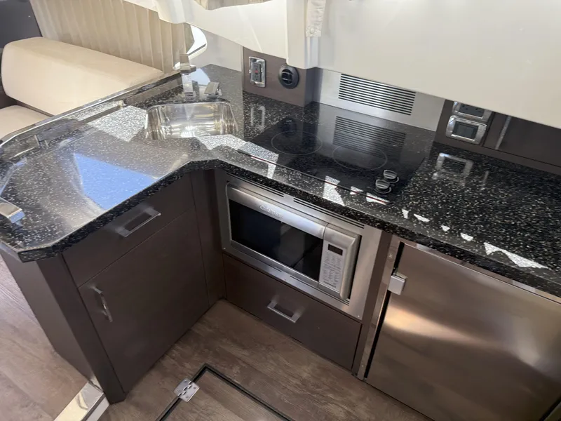 Slide: The Image of Modern kitchen in 2014 Marquis 420 Sport Bridge yacht with granite countertops and stainless steel appliances. - 49