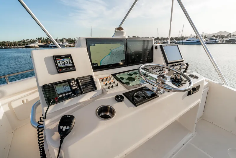 Slide: The Image of Helm of 2002 Cabo 35 Flybridge with navigation equipment and steering wheel, docked at marina. - 12
